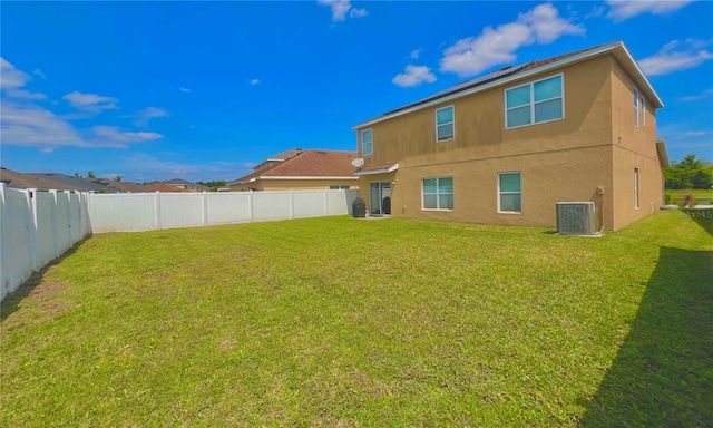 back of house with a yard and central air condition unit