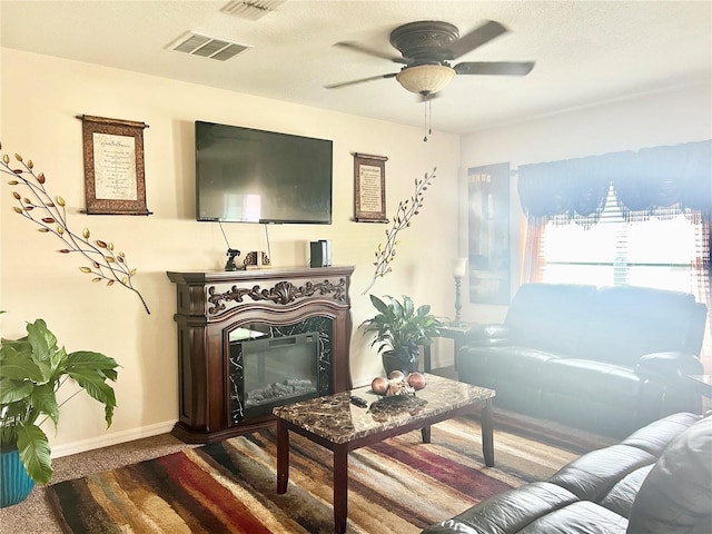 carpeted living room with a premium fireplace and ceiling fan