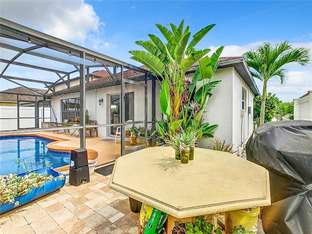 view of pool with glass enclosure and a patio