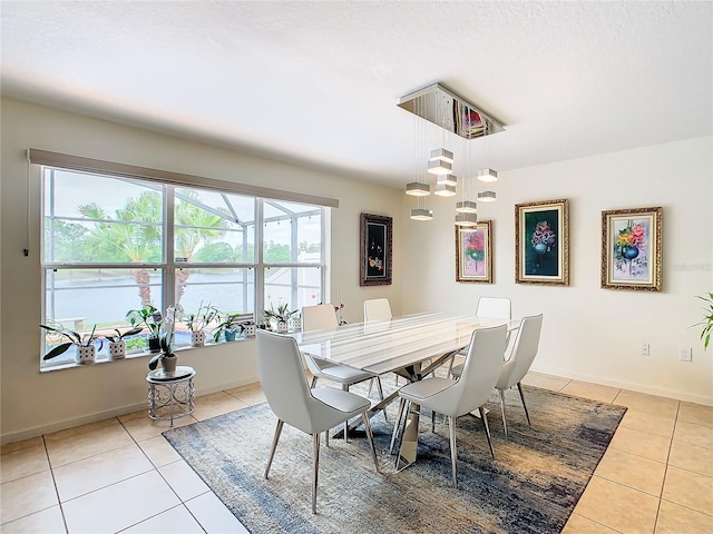 tiled dining room featuring a notable chandelier