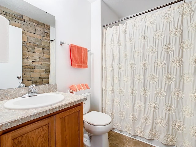 bathroom with toilet, large vanity, and tile flooring