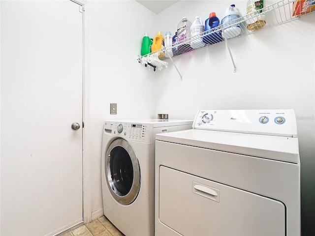 laundry room featuring washer and clothes dryer and light tile floors