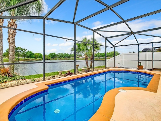 view of swimming pool featuring glass enclosure, a patio, and a water view