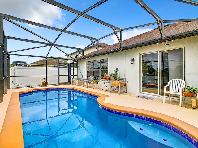 view of swimming pool with a patio area and glass enclosure