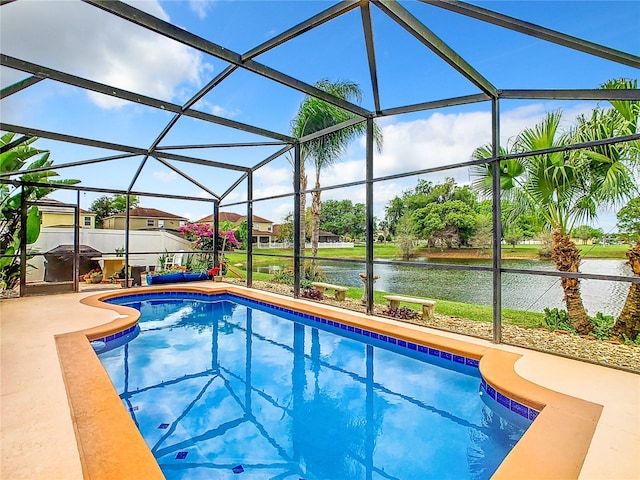 view of swimming pool with glass enclosure, a water view, and a patio