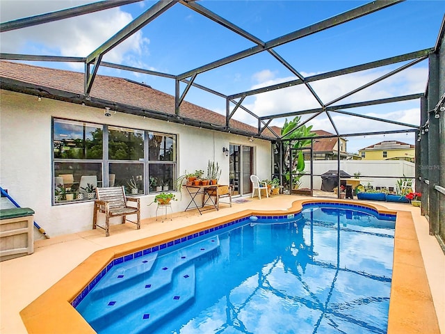 view of swimming pool with a patio area, a grill, and a lanai