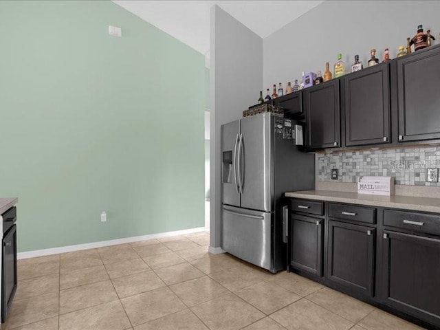 kitchen featuring backsplash, stainless steel fridge, high vaulted ceiling, and light tile patterned flooring