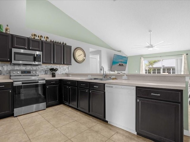 kitchen with ceiling fan, light tile patterned floors, sink, lofted ceiling, and stainless steel appliances