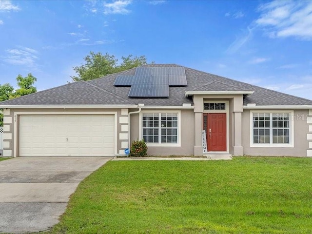 view of front of property with solar panels, a garage, and a front lawn