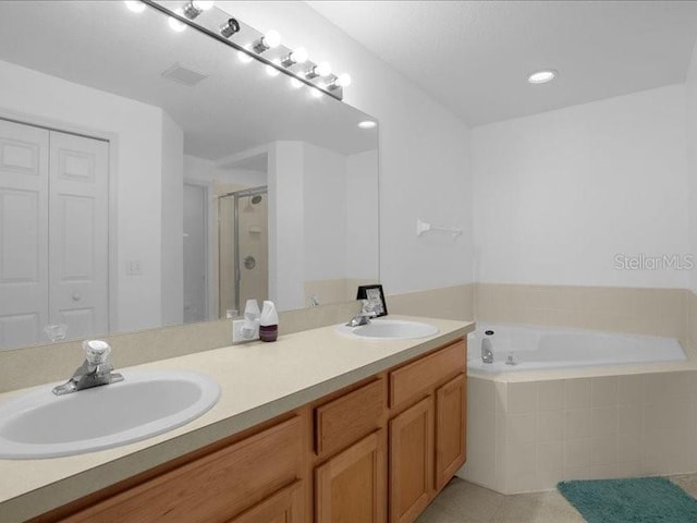 bathroom featuring shower with separate bathtub, double vanity, and tile patterned floors