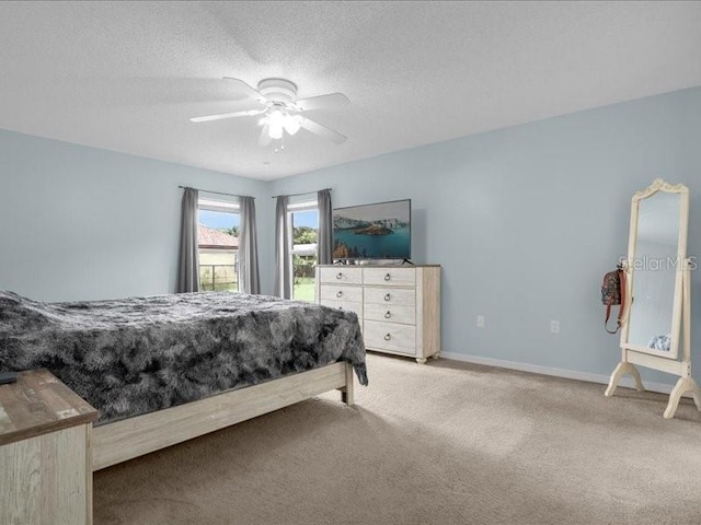 bedroom with a textured ceiling, ceiling fan, and light colored carpet