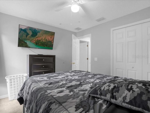 bedroom with carpet, a closet, a textured ceiling, and ceiling fan