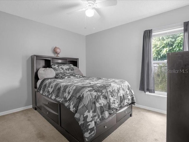 bedroom featuring ceiling fan and light carpet