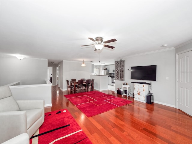 living room featuring hardwood / wood-style flooring, ceiling fan, and crown molding