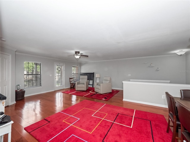 living room featuring hardwood / wood-style flooring, ceiling fan, and crown molding