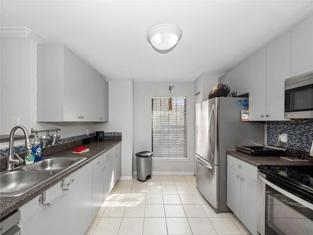 kitchen featuring white cabinets, sink, appliances with stainless steel finishes, tasteful backsplash, and light tile patterned flooring