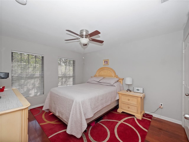 bedroom with dark hardwood / wood-style flooring and ceiling fan