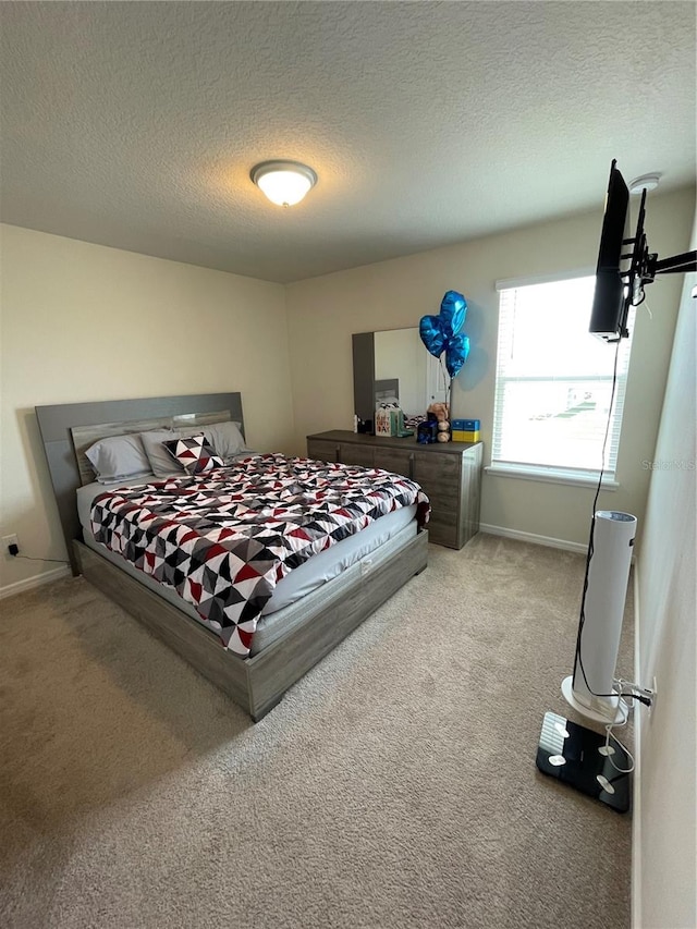 bedroom featuring light colored carpet and a textured ceiling