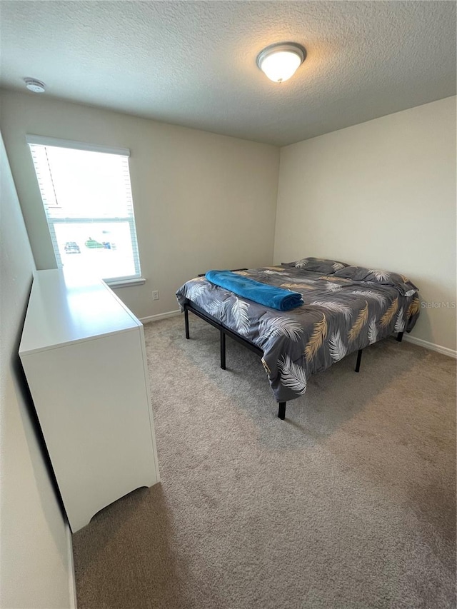 carpeted bedroom featuring a textured ceiling