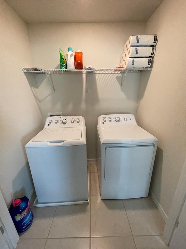 laundry area with light tile floors and washing machine and clothes dryer