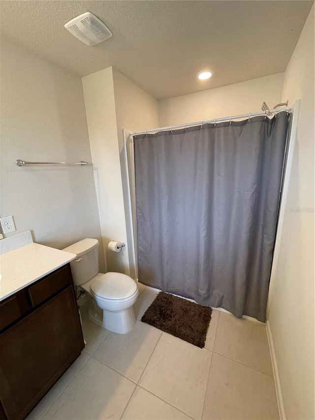 bathroom with vanity, tile flooring, a textured ceiling, and toilet