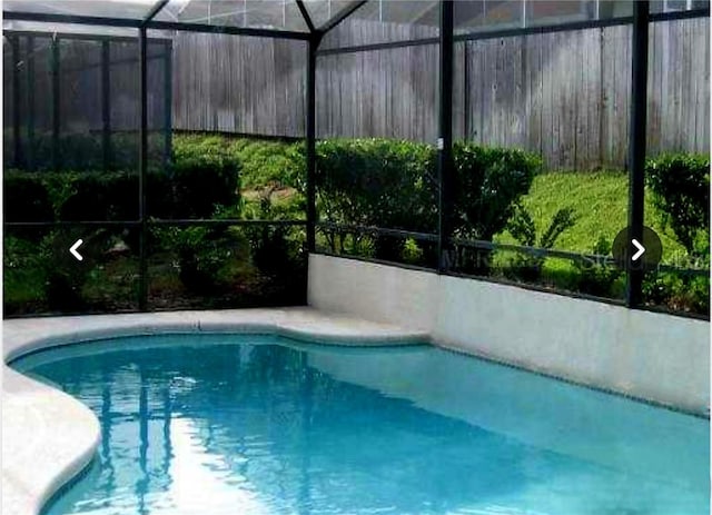 view of swimming pool featuring a lanai