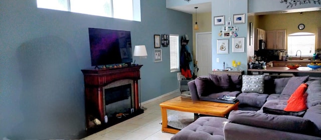 tiled living room with sink, a high ceiling, and a healthy amount of sunlight