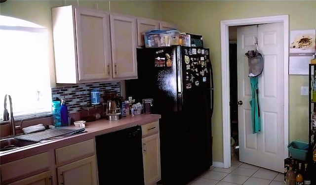 kitchen with white cabinets, backsplash, light tile flooring, and black appliances