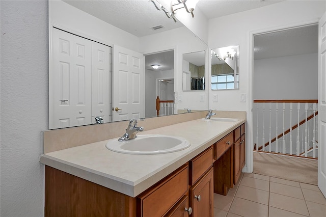 bathroom featuring vanity, tile patterned floors, and a textured ceiling