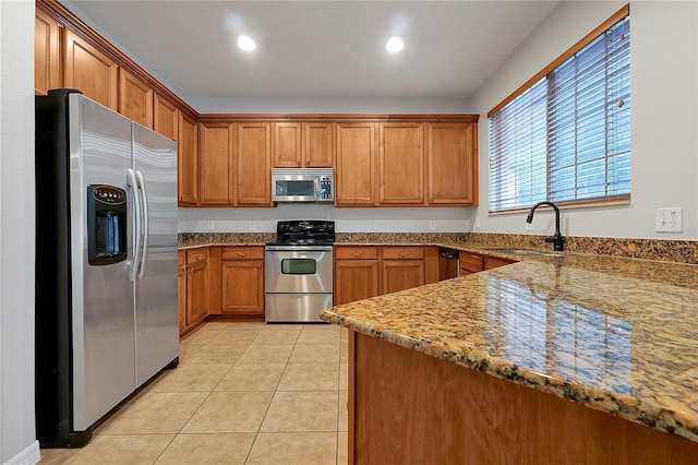 kitchen featuring light stone counters, appliances with stainless steel finishes, sink, and light tile patterned floors