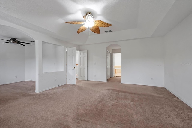 carpeted spare room with a textured ceiling, a raised ceiling, and ceiling fan