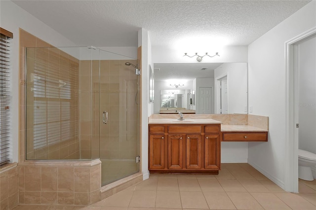 bathroom featuring vanity, tile patterned floors, a shower with door, and a textured ceiling