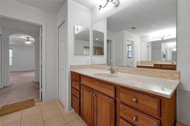 bathroom with ceiling fan, tile patterned floors, a textured ceiling, and vanity