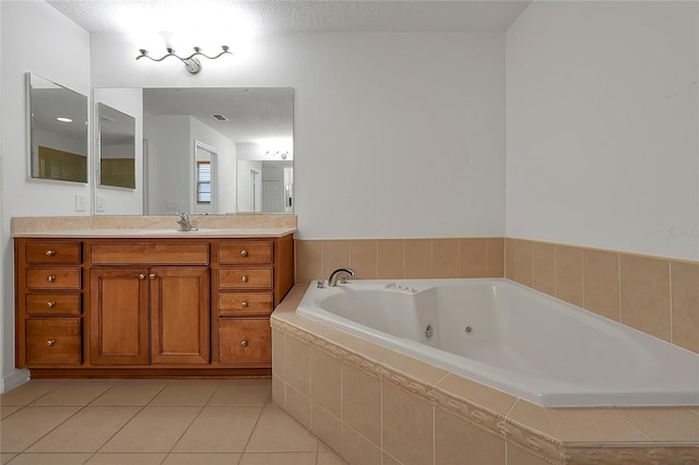 bathroom featuring tile patterned flooring, vanity, tiled tub, and a textured ceiling