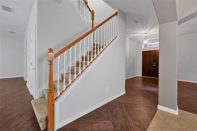 stairway featuring parquet floors