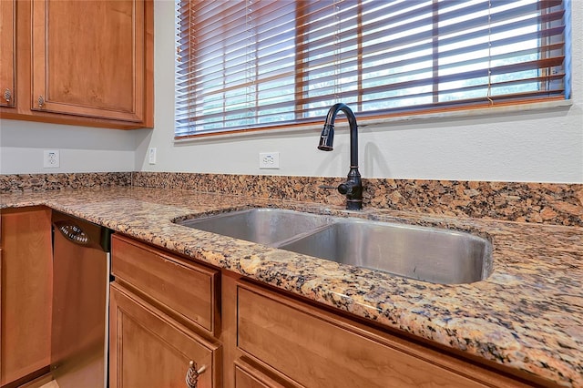 interior space featuring light stone counters, dishwasher, and sink