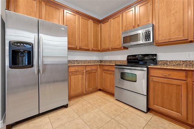 kitchen with light stone counters, stainless steel appliances, and light tile patterned flooring