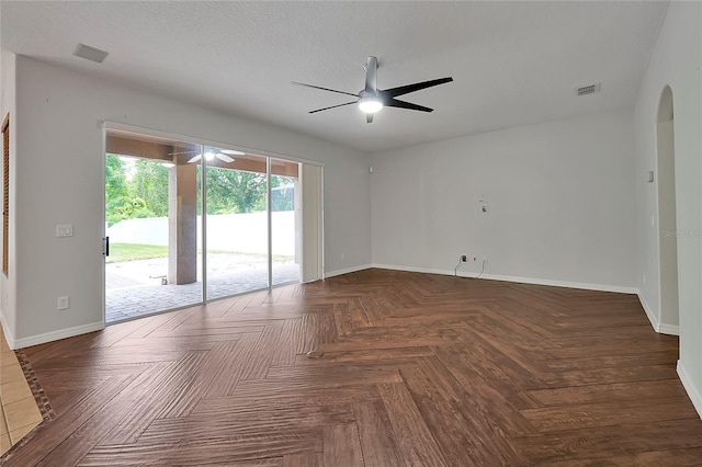 unfurnished room featuring dark parquet flooring, a textured ceiling, and ceiling fan