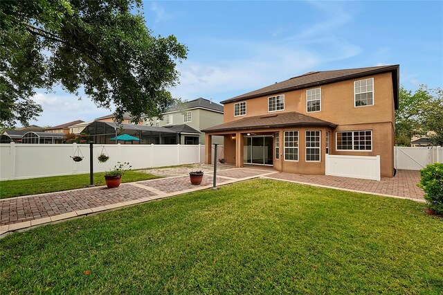 rear view of house featuring a yard and a patio area