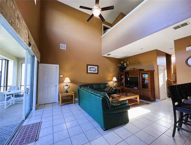 tiled living room featuring ceiling fan and high vaulted ceiling