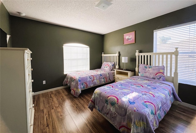 bedroom featuring a textured ceiling and dark wood-type flooring