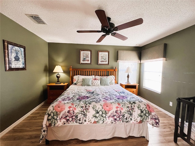 bedroom featuring dark hardwood / wood-style floors, a textured ceiling, and ceiling fan