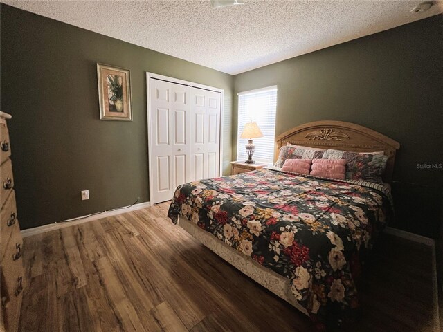 bedroom featuring a textured ceiling, dark wood-type flooring, and a closet