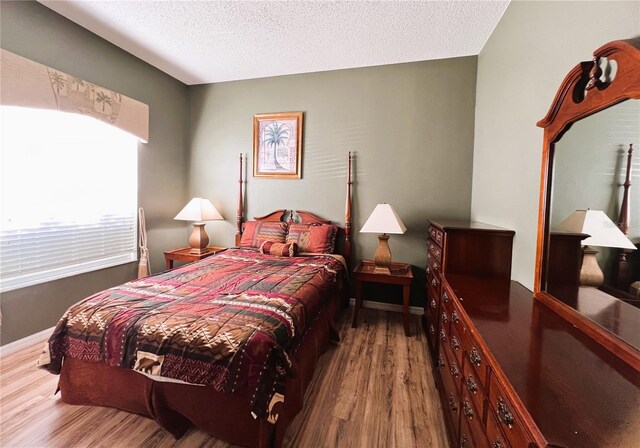 bedroom featuring a textured ceiling and hardwood / wood-style floors