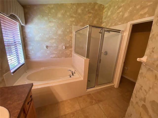 bathroom featuring plus walk in shower, vanity, and a wealth of natural light