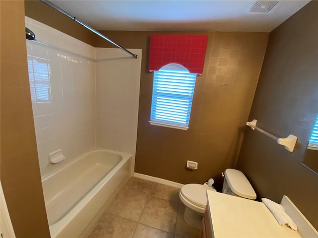 full bathroom with tile patterned floors, vanity, tiled shower / bath combo, and toilet