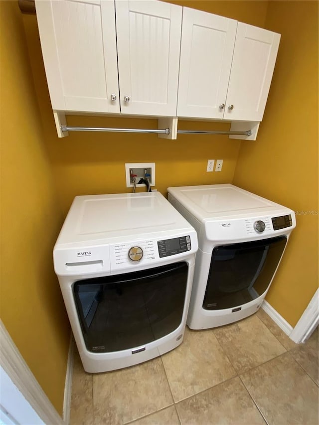 washroom featuring cabinets, independent washer and dryer, and light tile patterned floors