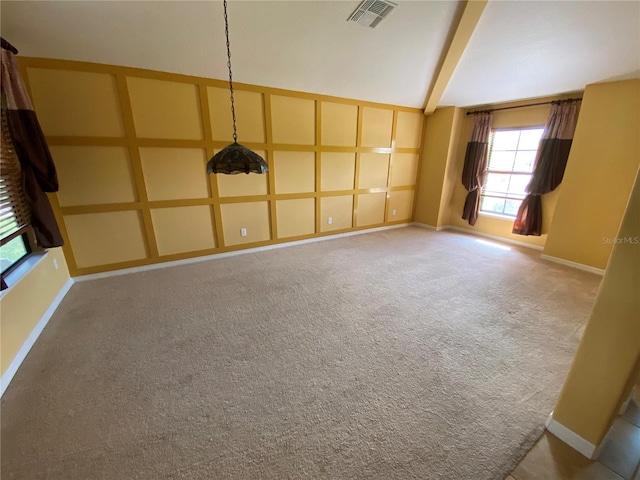 carpeted spare room featuring beamed ceiling