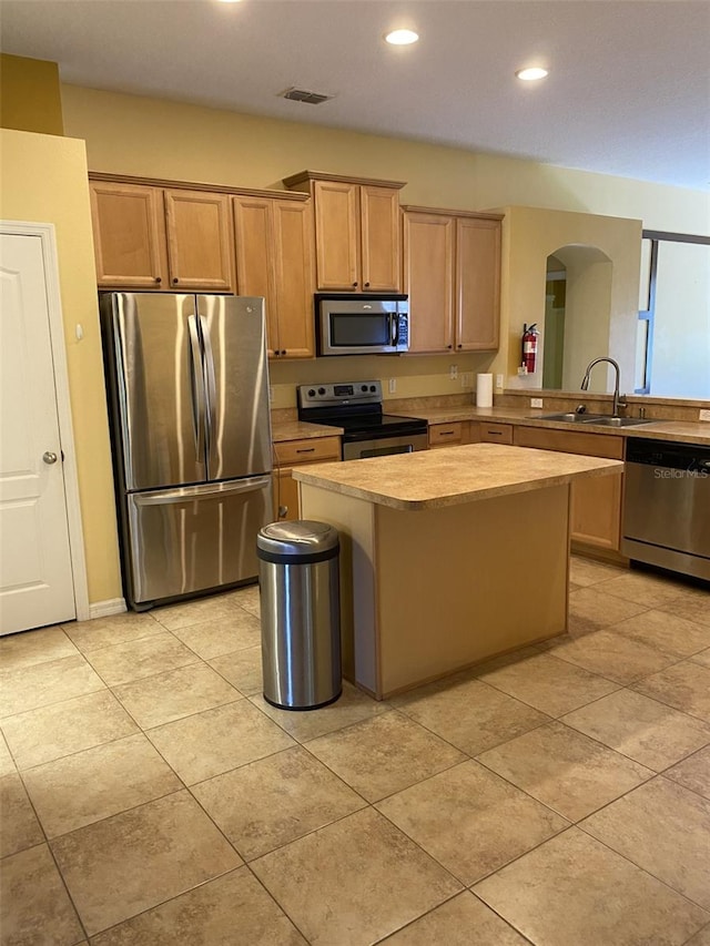 kitchen featuring a breakfast bar, appliances with stainless steel finishes, a kitchen island, and sink