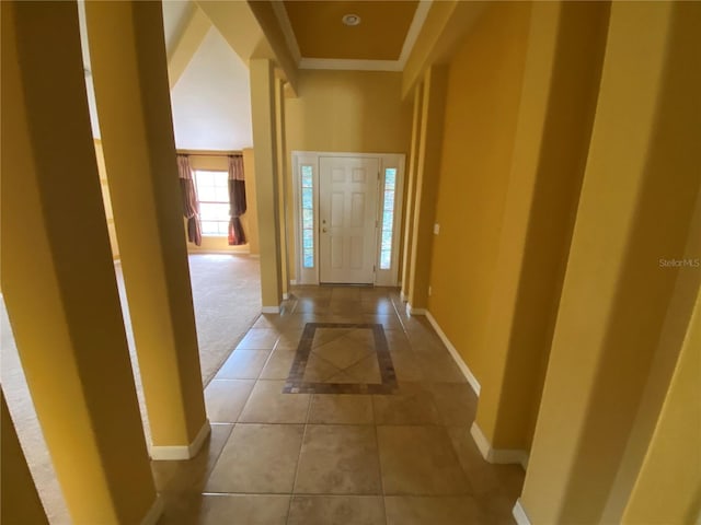 foyer entrance with light tile patterned flooring and a towering ceiling